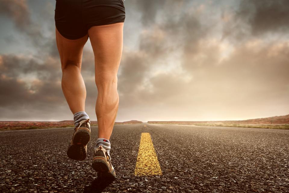 A runner on an open road at dusk